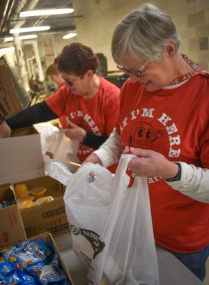 Left to right, Donna Reer, Suzanne Good and Patti Gray pack bags of food for students at Bellevue Elementary School.