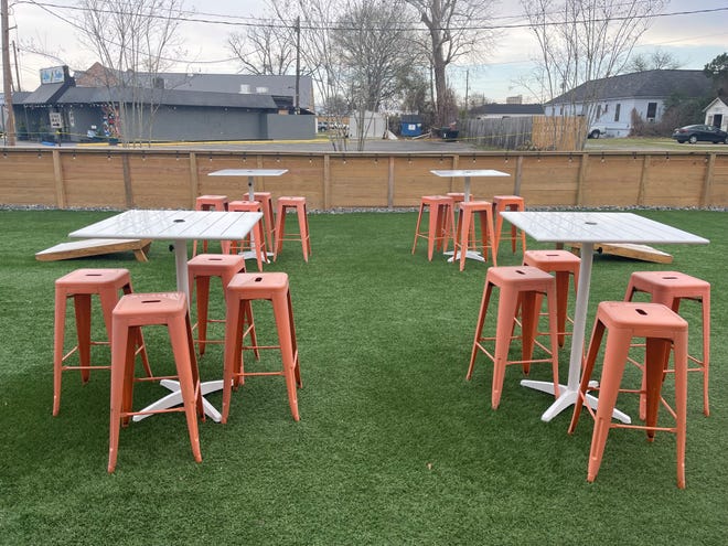 The front patio of Okaloosa restaurant in Monroe is placed on AstroTurf, and features cornhole boards and high-top picnic tables.