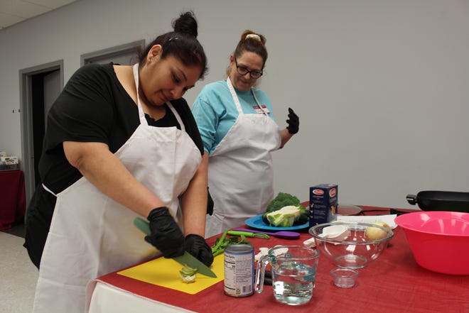 Katrina dices up celery to make a winter Italian vegetable dish with her friend Kenna at the Cooking Arkansas Class in Van Buren, March 10, 2022.