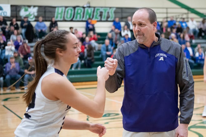 Athens High School head coach Calvin Quist fist bumps each player before the start of this regional final game at Mendon High School on Wednesday, March 10, 2022.