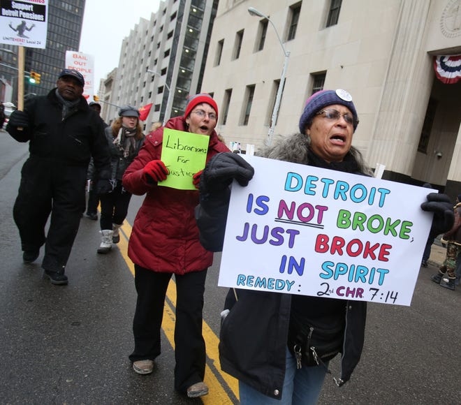 Renla Session, of Detroit, marches in a protest during Detroit's municipal bankruptcy case outside the federal courthouse on Lafayette Boulevard, Dec. 3, 2013.