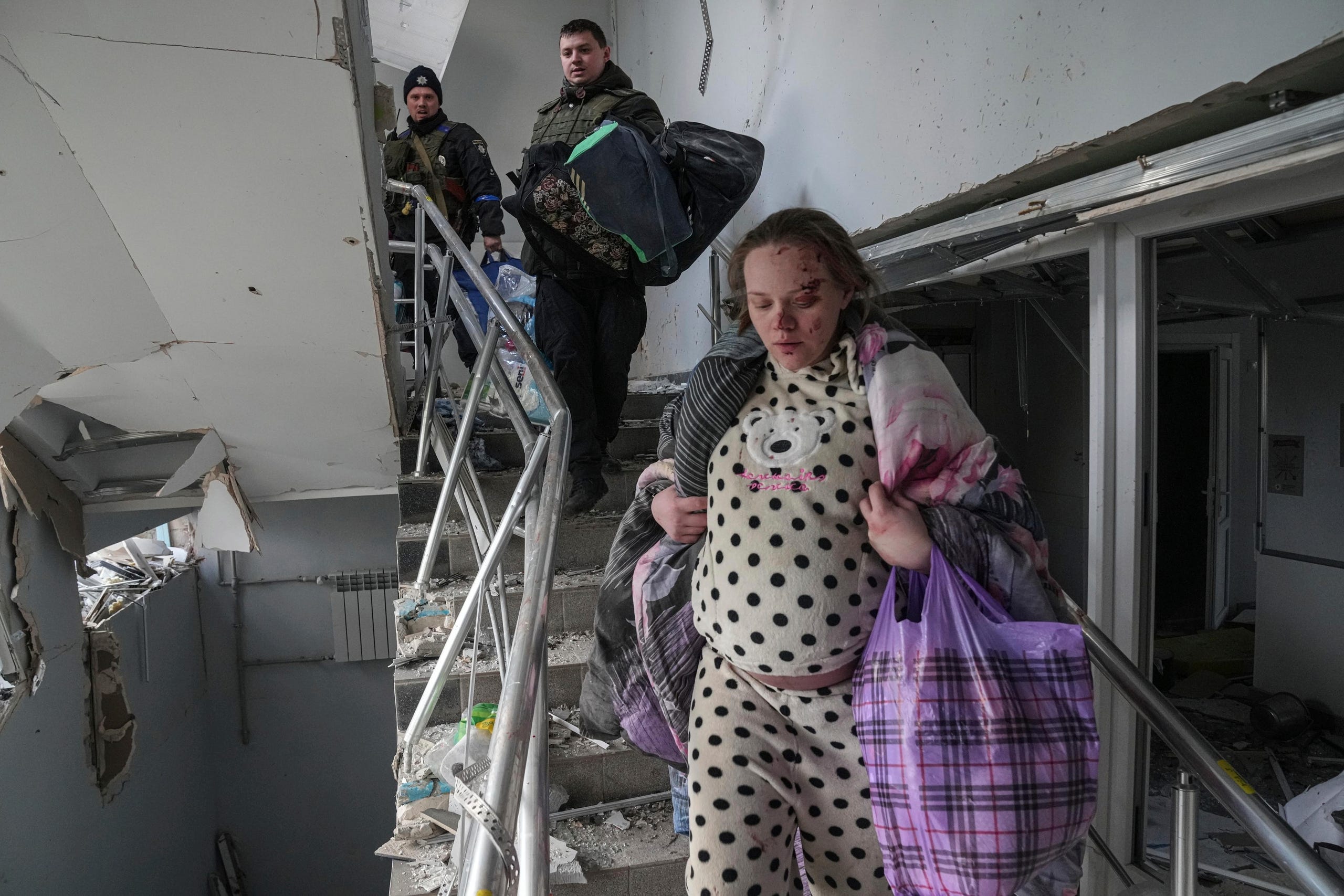 An injured pregnant woman walks downstairs in a maternity hospital damaged by shelling in Mariupol, Ukraine, Wednesday, March 9, 2022. (AP Photo/Evgeniy Maloletka) ORG XMIT: NYAG513