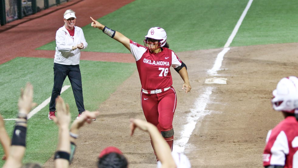 Oklahoma softball coach Patty Gasso (left) claps as slugger Jocelyn Alo heads to home plate on March 11 after hitting her 96th career home run in the Sooners' 11-0 win at Hawaii.