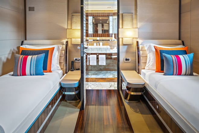 The guest stateroom features light wood finishes, set off with white and pops of bright colors.