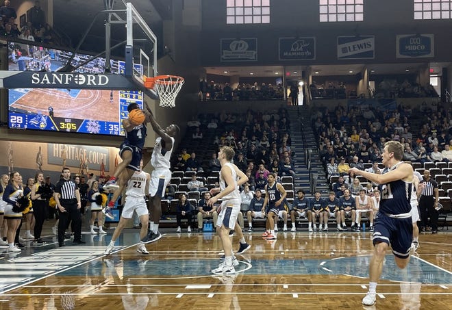 Mark Berry of Southwest Oklahoma State tries to make a move under the basket as Augustana's Akoi Akoi defends during Saturday's Division II NCAA tournament game at the Sanford Pentagon.