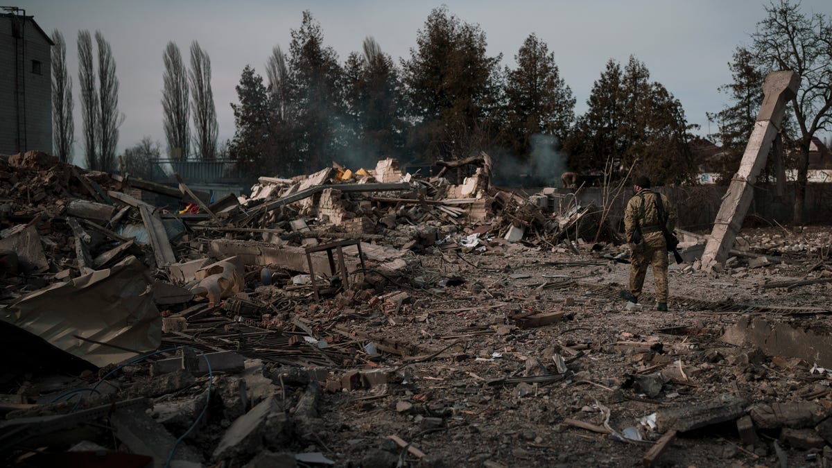 A volunteer of the Ukrainian Territorial Defense Forces walks on the debris of a car wash destroyed by a Russian bombing in Baryshivka, east of Kyiv, on Friday.
