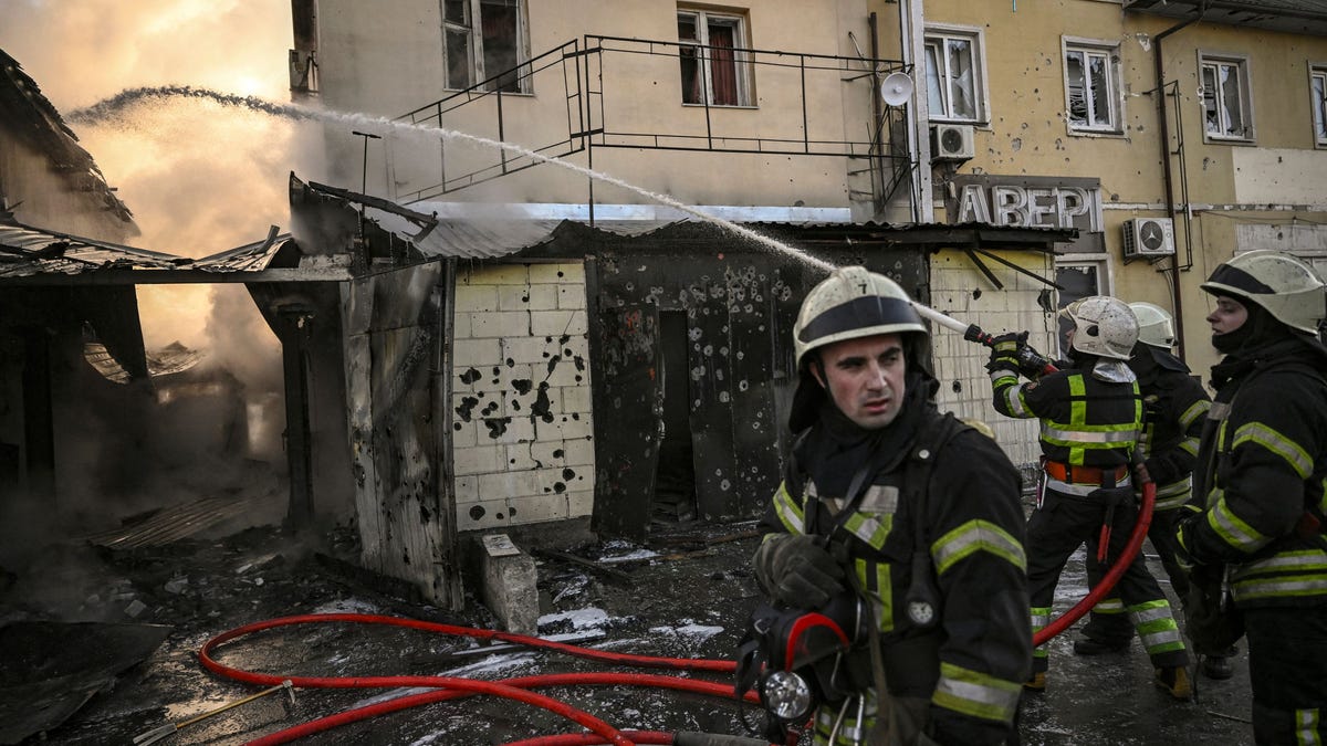Firefighters extinguish a fire on a house after shelling in Kyiv on March 12, 2022.
