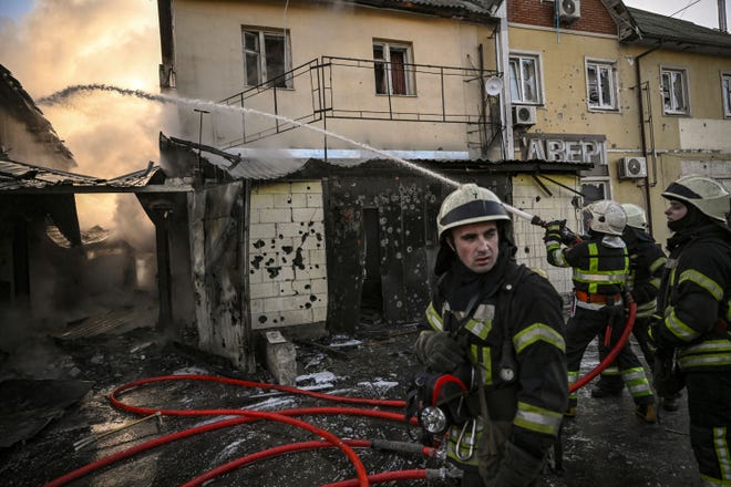 Firefighters extinguish a fire on a house after shelling in Kyiv on March 12, 2022.