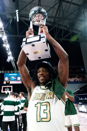UAB guard Quan Jackson holds up the trophy after the team's win over Louisiana Tech during an NCAA college basketball game for the championship of the Conference USA men's tournament in Frisco, Texas, Saturday, March 12, 2022. (AP Photo/LM Otero)