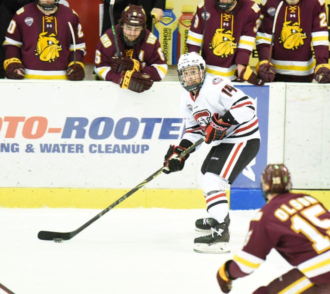 St. Cloud State junior Zach Okabe passes the puck Saturday, March 12, 2022, at Herb Brooks National Hockey Center in St. Cloud.