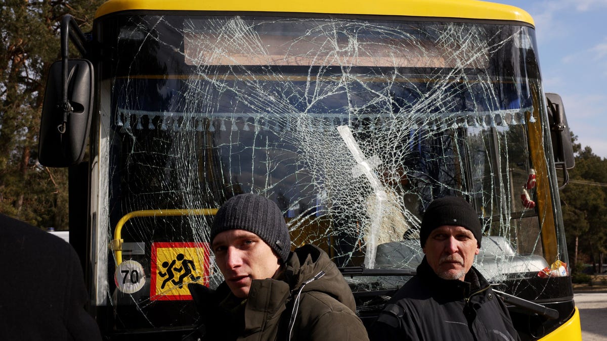 Yuri (R), a bus driver, and his son Ruslan, a doctor, stand in front of a bus damaged in this morning's air strikes at a nearby military complex, while they wait outside Novoiavorivsk District Hospital on March 13, 2022 in Novoiavorivsk, Ukraine. Early this morning, a series of Russian missiles struck the International Center for Peacekeeping and Security at the nearby Yavoriv military complex, killing at least nine and wounding dozens, according to Ukrainian   officials. The site is west of Lviv and mere miles from Ukraine's border with Poland, a NATO member.