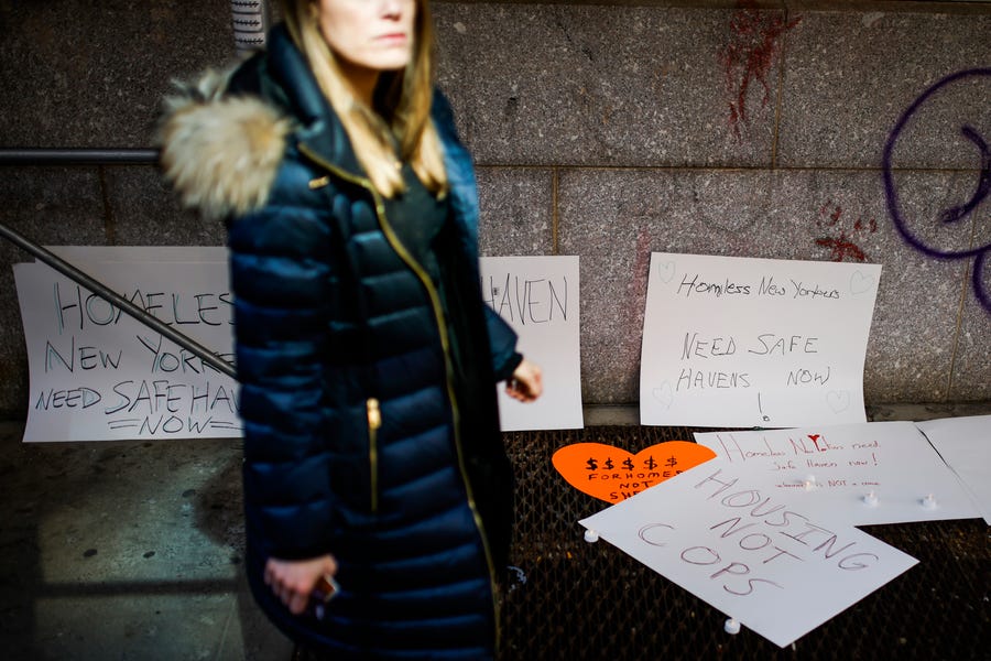 A pedestrian walks past by signs left as a memorial near the place where a homeless person was killed days earlier in lower Manhattan, Monday, March 14, 2022, in New York.