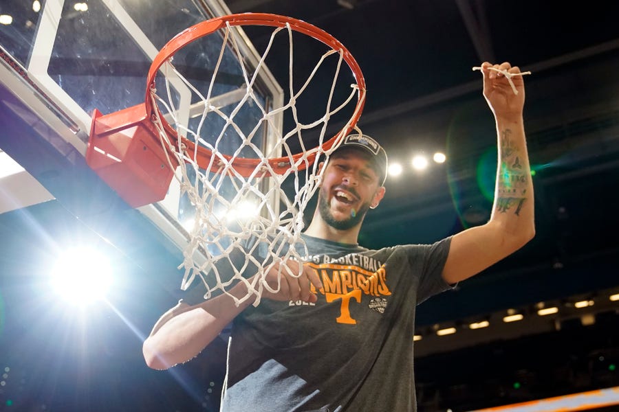 Tennessee forward Uros Plavsic cuts down part of the net after the team defeated Texas A&M during the Southeastern Conference tournament championship game.