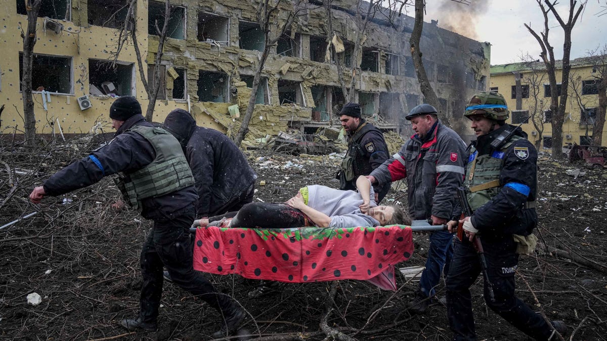 Ukrainian emergency employees and volunteers carry an injured pregnant woman from the maternity hospital that was damaged by shelling in Mariupol, Ukraine, Wednesday, March 9, 2022. The woman and her baby died after Russia bombed the maternity hospital where she was meant to give birth.