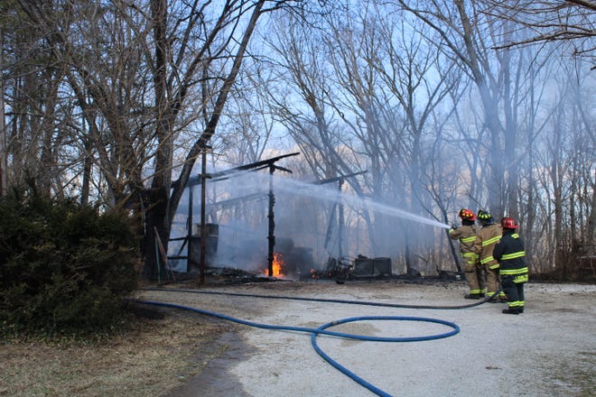 Local firefighters work to extinguish a shed fire in the 6100 block of State Road 252 Tuesday afternoon.