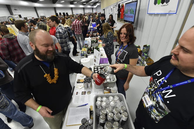 Corey Weinkoetz of MobCraft Beer of Milwaukee pours a sample of the brewery's Pivot Ale for Bill Gruhlke of Luxemburg at a past Roar Off The Shore Brewfest.