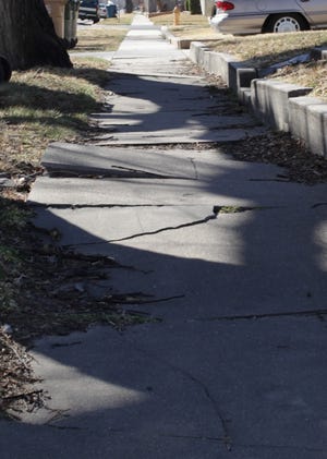This half-block of sidewalk on North Poplar Street has been broken up by large tree roots, cracking the sidewalk and sending slabs of concrete jutting up, making it difficult terrain for walkers and wheelchairs alike.