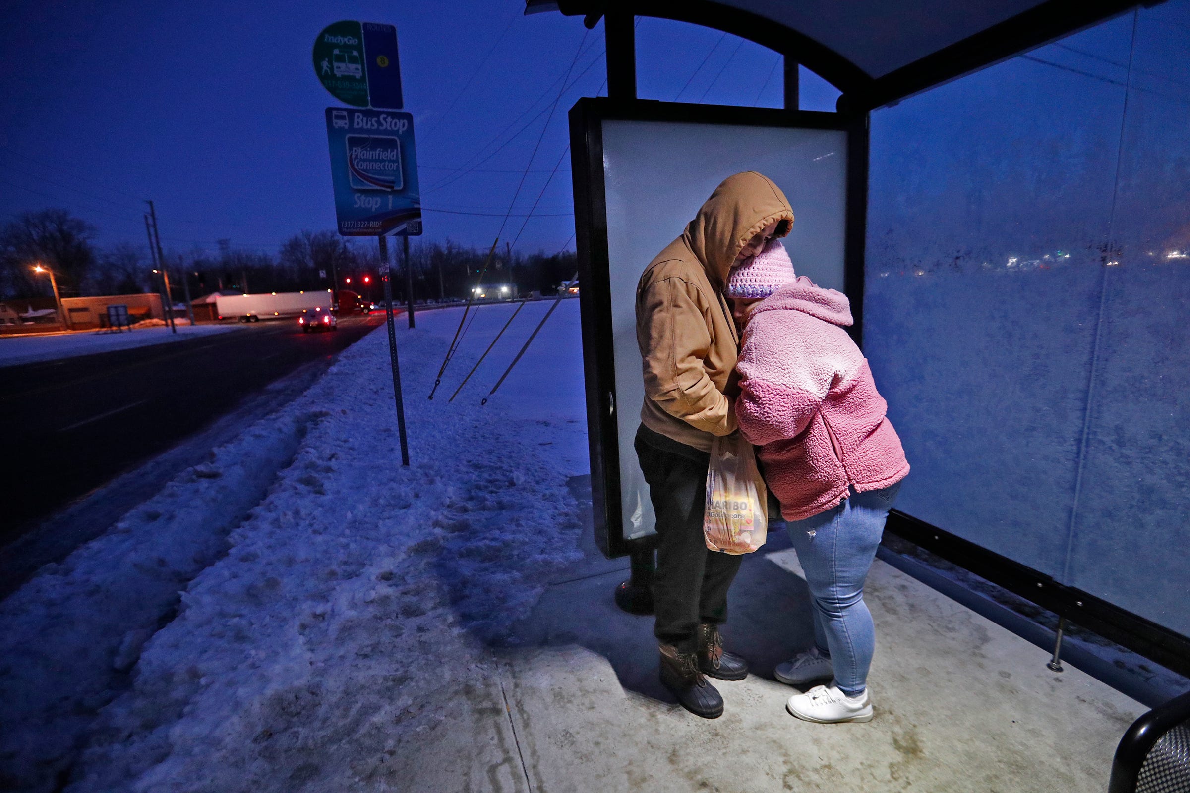 Sulaman and Arzo Akbarzada try to stay warm as they wait for their Uber on their way to work at Harlan Bakeries, Monday, Feb. 7, 2022 from Indianapolis to Avon. This day, the young couple took two buses and an Uber to get from Indianapolis to Avon for work.