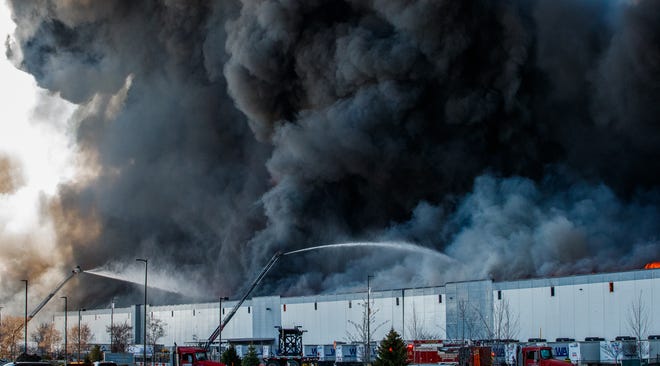 A massive fire burns inside a Walmart fulfillment center in Plainfield, Ind., near the Indianapolis International Airport.