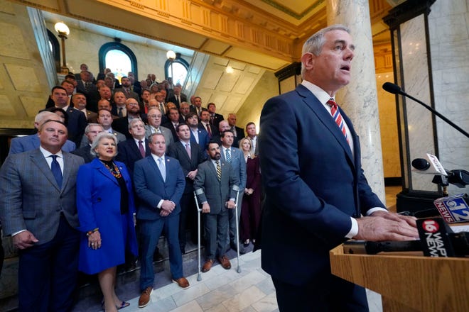 Flanked by most of the Republican members of the House, Speaker Philip Gunn, R-Clinton, presents to reporters the House's position on their state income tax elimination legislation at the Mississippi Capitol in Jackson, Tuesday, March 15, 2022.