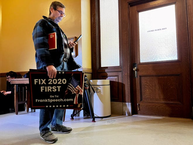 A supporter of decertifying the 2020 election from southern Wisconsin, who did not wish to be identified, stands outside a Capitol hearing room Wednesday, March 16, 2022, as Assembly Speaker Robin Vos met with a group pushing to decertify.