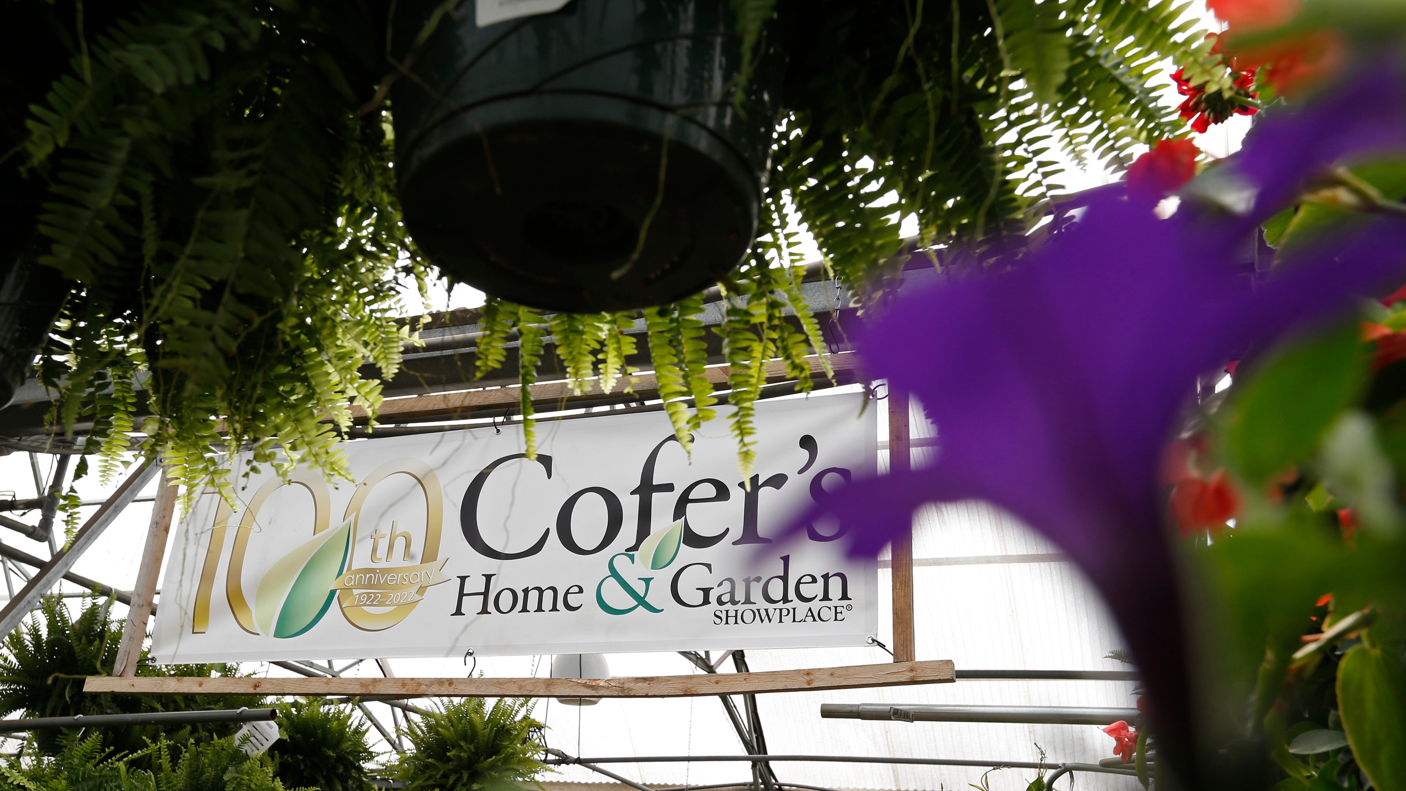 A commemorative 100th-anniversary sign hangs at Cofer's Home & Garden nursery in Athens, Ga., on Thursday, March 17, 2022. The home & garden store celebrates its 100th anniversary this year.