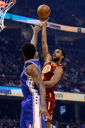 Cleveland Cavaliers' Evan Mobley (4) shoots against Philadelphia 76ers' Joel Embiid during the first half of an NBA basketball game Wednesday, March 16, 2022, in Cleveland. (AP Photo/Ron Schwane)