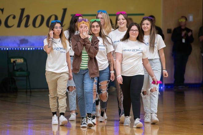 Mikaela Naylon, second from left, walks into the Pueblo County High School gymnasium to cheers at the start of the school's "Wish Week" assembly on Thursday, March 17, 2022.