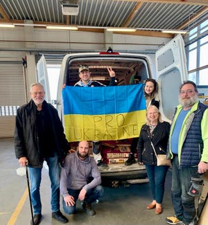 Vera Busch, second from right, stands with a team of Pro Ukraine volunteers in front of one of the organization's transport vans.