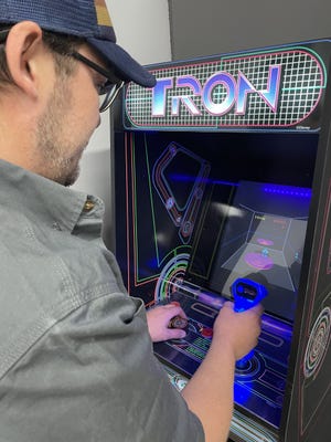 Mark Skelton plays the arcade game Tron: Discs of Tron, installed at the Electric Ramen restaurant in Genoa, on Wednesday, March 16, 2022.