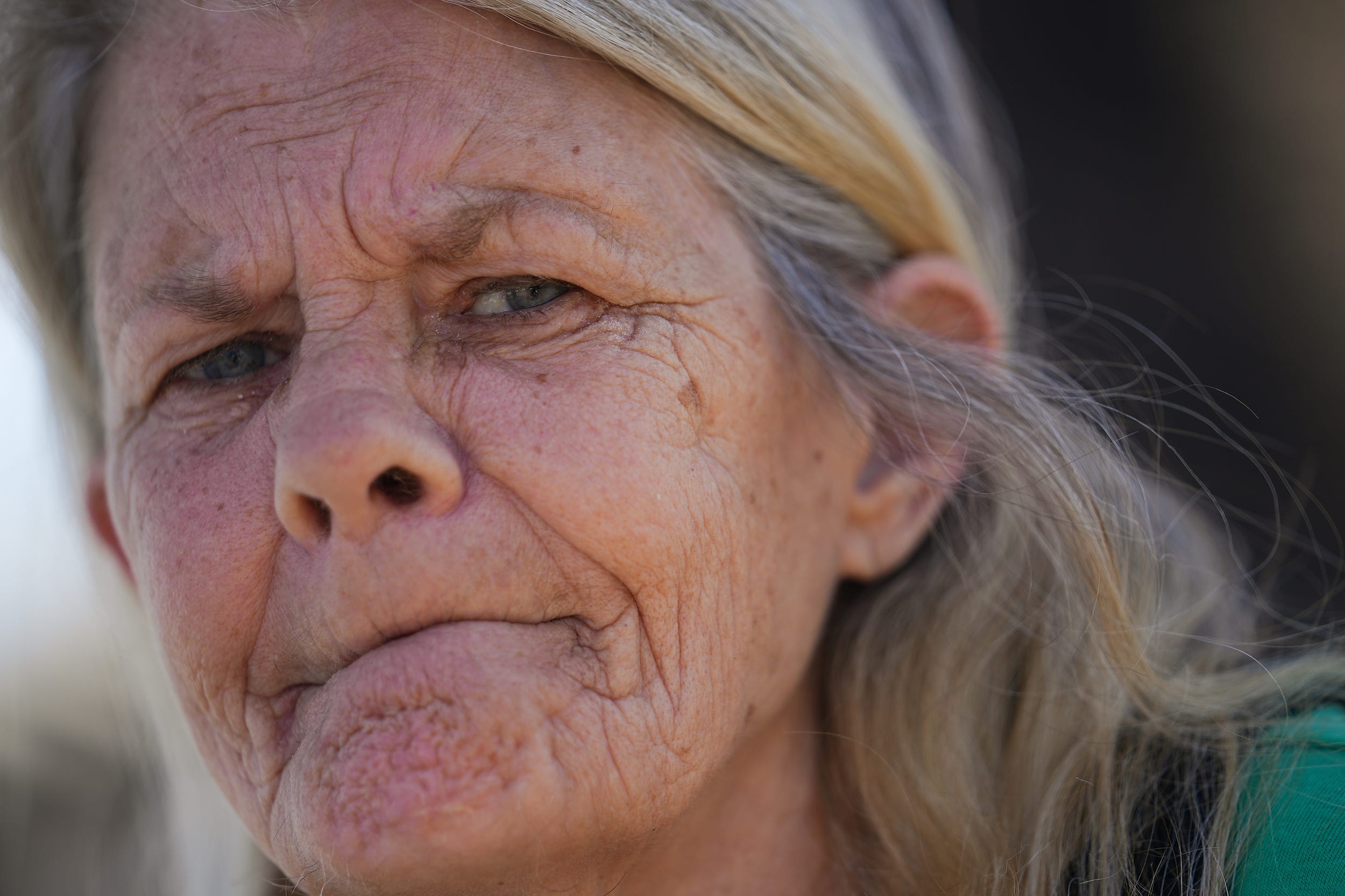 Carol Parker, 61, poses for a portrait outside her new apartment complex on Tuesday, March 15, 2022, in Phoenix. Parker was left homeless after her previous landlord decided not to accept a low-income housing voucher Parker uses to afford rent. She has osteoporosis and ended up fracturing her back in five places while living homeless. Through the help of Circle the City and over a hundred calls to landlords, she found a building that had space and would take her voucher.