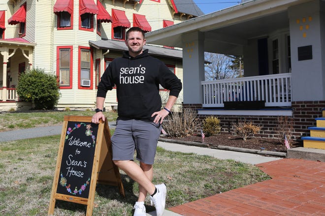Scott Day, Executive Director of Sean's House, stands next to a sign welcoming visitors to the Newark home. The site, named after Sean Locke who committed suicide in 2018, acts a safe haven for teenagers and young adults.