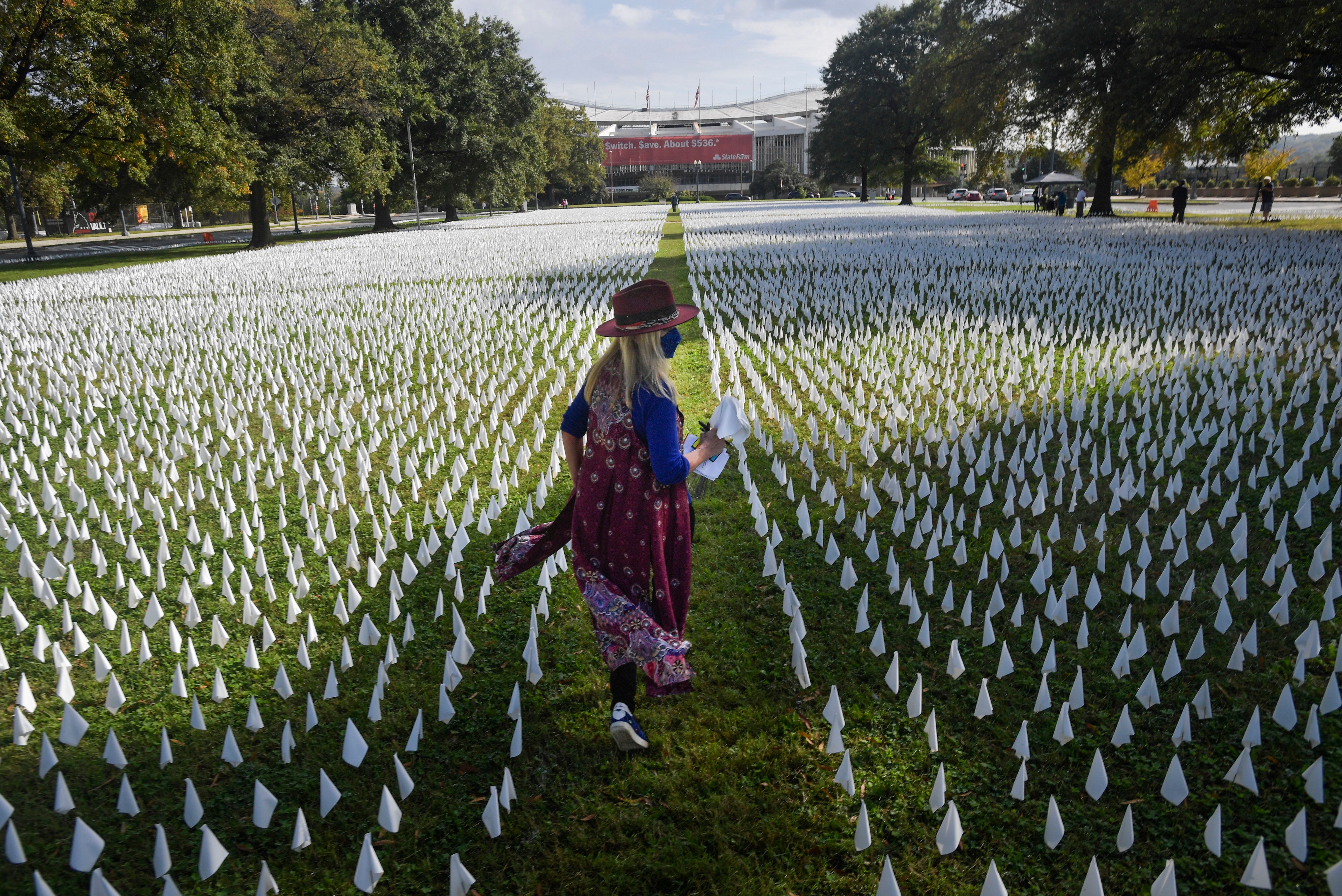 The "IN AMERICA: How Could This Happen" project artist Suzanne Firstenberg walks through the installation on the DC Armory Parade Ground on Friday, October 23, 2020 in Washington, DC. The project honors each of the nearly 225,000 lives lost in the U.S. due to COVID-19 with a white flag.