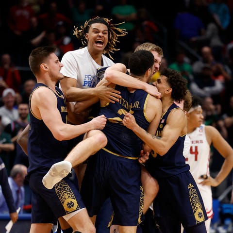 The Notre Dame Fighting Irish storm the court afte