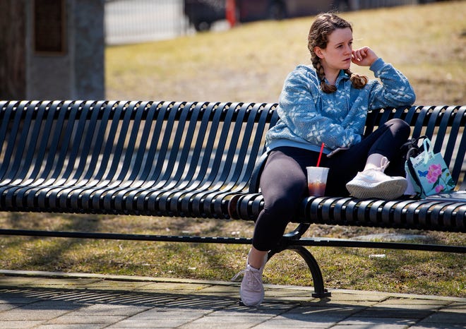 Kate Killion perches on a Worcester Common bench Friday, as temperatures climbed into the 60s by midday.