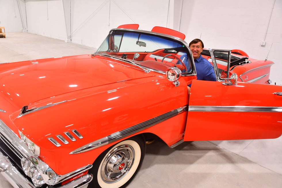 American Muscle Car Museum owner Mark Pieloch sits in his 1958 Chevrolet Impala convertible with Rio Red paint and tri-tone interior that he is taking to the Barrett-Jackson auction in West Palm Beach.