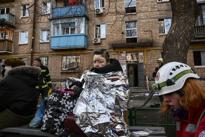 Seorang wanita yang terluka melihat saat dia menerima perawatan medis setelah penembakan di daerah perumahan di Kyiv pada 18 Maret 2022, ketika pasukan Rusia mencoba mengepung ibukota Ukraina sebagai bagian dari serangan yang bergerak lambat.