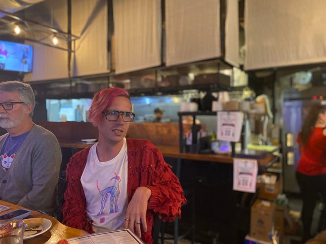 Food and travel writer Matt Kirouac prepares to take a bite of a pot roast egg roll at 86 Forks Bar + Table.