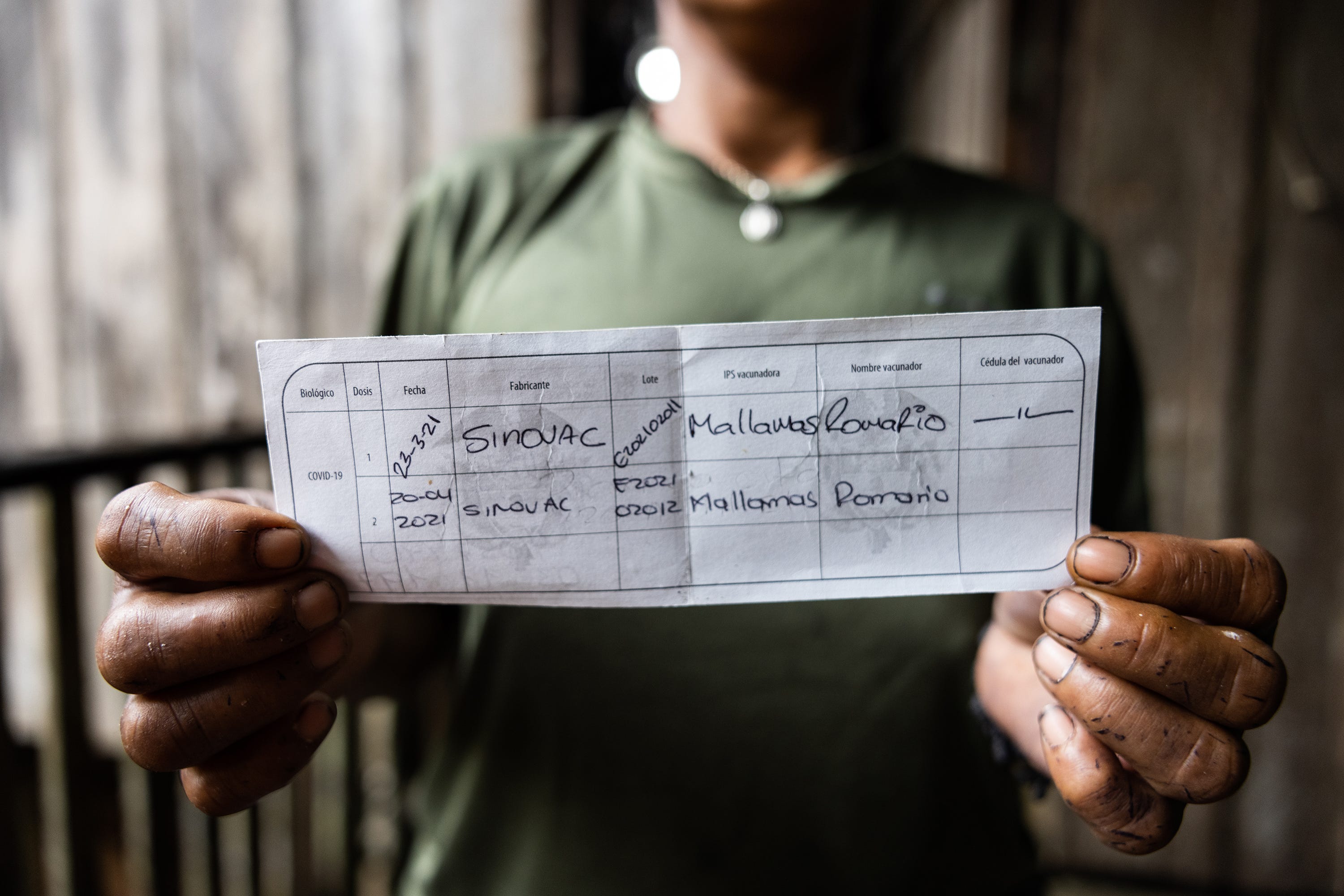 Nallive Parente, 42, shows her vaccination card with the two doses she has received. The Ticuna nurse Romario Mujica gave her the shots.