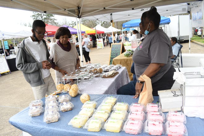 Jean Bradford (second from left) and grandson Khristopher Bradford visit with Linda Gaston at her booth at the Alexandria Farmers Market which is held from 3-6 p.m. every Tuesday at 2727 Jackson St.