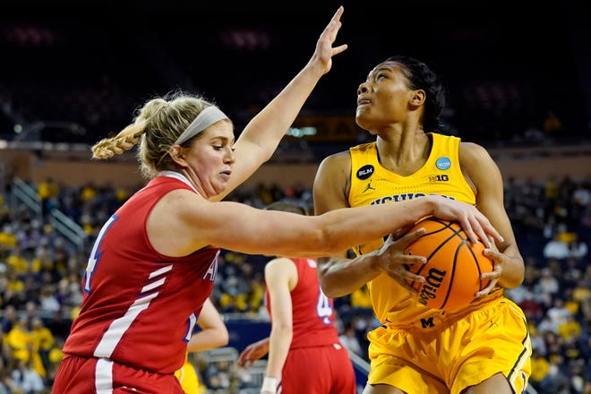 American forward Taylor Brown reaches in and steals the ball from Michigan forward Naz Hillmon during the first half of a college basketball game in the first round of the NCAA tournament, Saturday, March 19, 2022, in Ann Arbor, Mich.