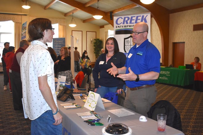 Miles Abraham, left, a senior at Adrian High School listens to information about what Creek Enterprise Inc., a national company with headquarters in Adrian that provides infrastructure and application services, has to offer during the Career Connections job fair Friday at Adrian College. Representatives from Creek Enterprise, 638 W. Maumee St., at the job fair were Ashley King, office manager, and Tom Lucha, executive sales.