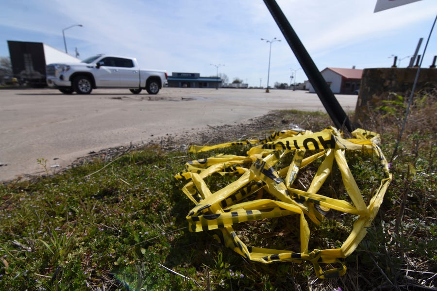 Crime scene tape lies on the ground, Sunday, March 20, 2022 at the scene where a shooting that left over 20 injured and one dead occurred Saturday night in Dumas, Ark. (Staci Vandagriff/The Arkansas Democrat-Gazette via AP)