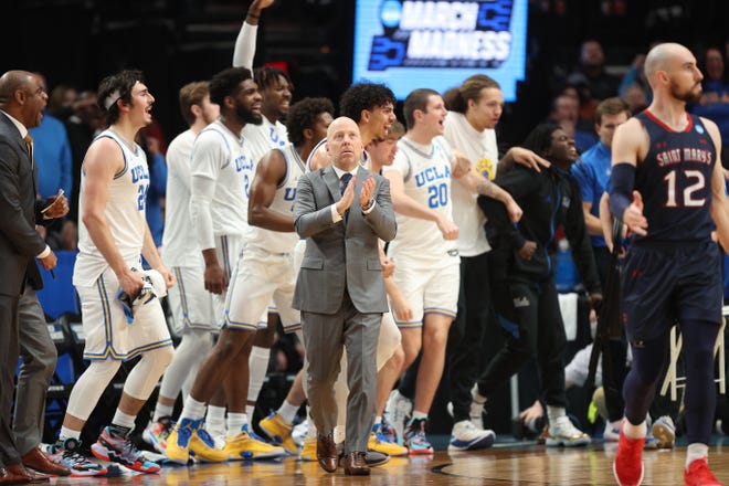 Mick Cronin of the UCLA Bruins and the players celebrate after forcing a shot clock violation during the first half against the St. Mary's Gaels.