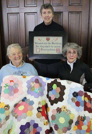 Trinity Episcopal quilters Andrea Johnson (left), Diane Steinman-Jones and Julia Domick (Sylvia Pixley is not pictured) recently completed a quilt, 74 by 91 inches in size, using a topper that was donated by Terea Zelt of West Virginia, Domick’s childhood friend.