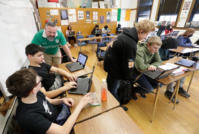 Eighth grade teacher Shayne Porter helps Darion Asplund and Dorion Skaeski with an American History project Thursday, March 17, 2022, at Wilson Middle School in Appleton, Wis.