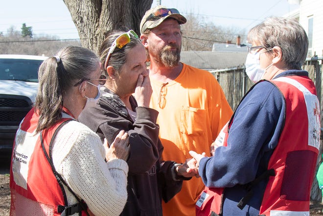 Lori Brown, second from left, is comforted by members of the local Red Cross after a morning fire cost the life of her mother and destroyed the family home at 268 South Hickory Street on March 21, 2022. 