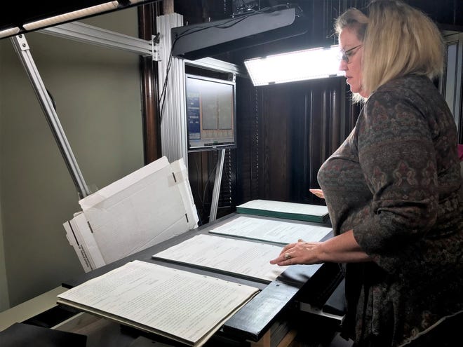 Project Manager Yolonda VanDyne of Family Search reviewing court records from the Coshocton County Clerk of Courts Office for digital scanning. Volunteers scanned close to 243,000 images. The public records are available for family genealogy research and the clerk's office has copies of the scans on thumb drives.