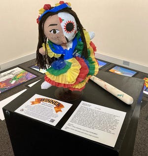 Emmilia Flores, a senior at Ridgewood High School, recently won the the Racial Justice arts contest for her artwork depicting a piñata and bat. It's on display until May 8 at the Johnson-Humrickhouse Museum.