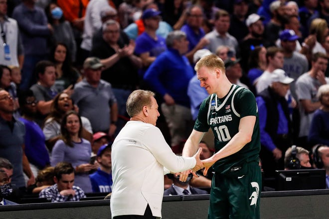 Michigan State coach Tom Izzo shakes hands with forward Joey Hauser as he comes off the court against Duke during the second half of MSU's 85-76 loss in the second round of the NCAA tournament on Sunday, March 20, 2022, in Greenville, South Carolina .
